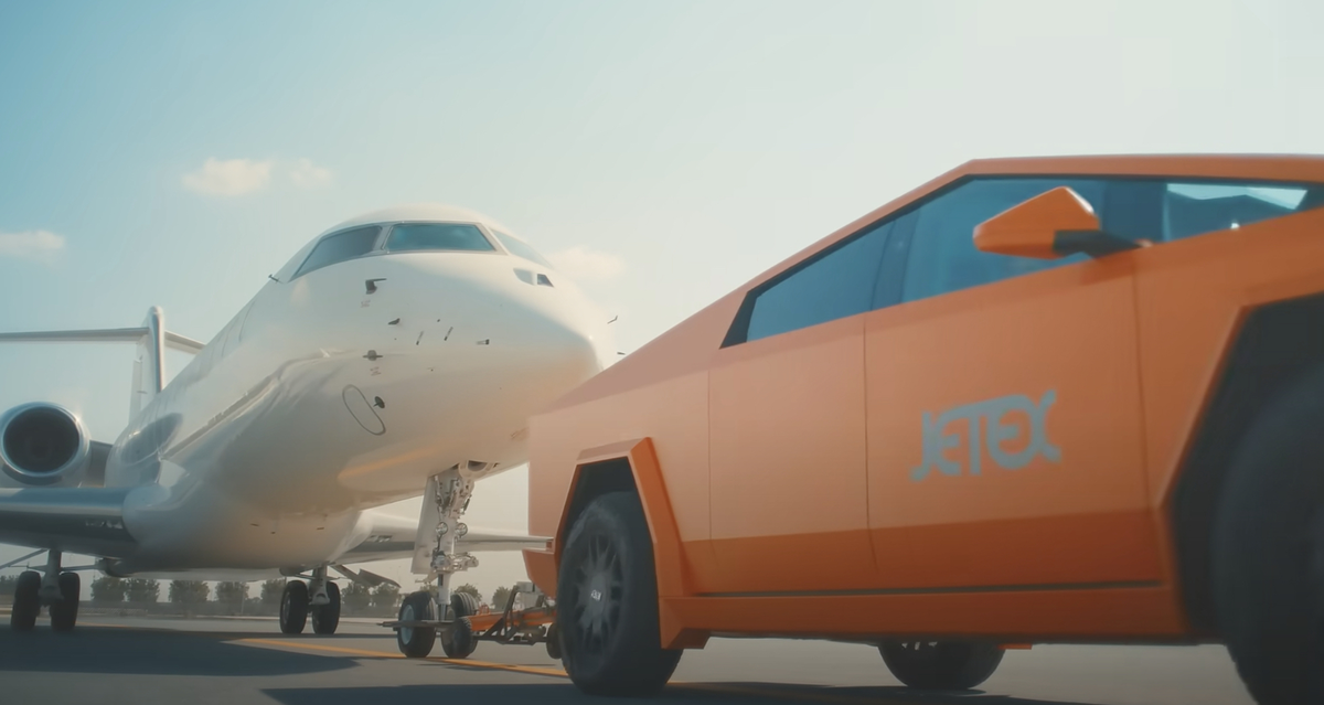 En toute tranquillité, ce Cybertruck (orange) tracte un jet privé