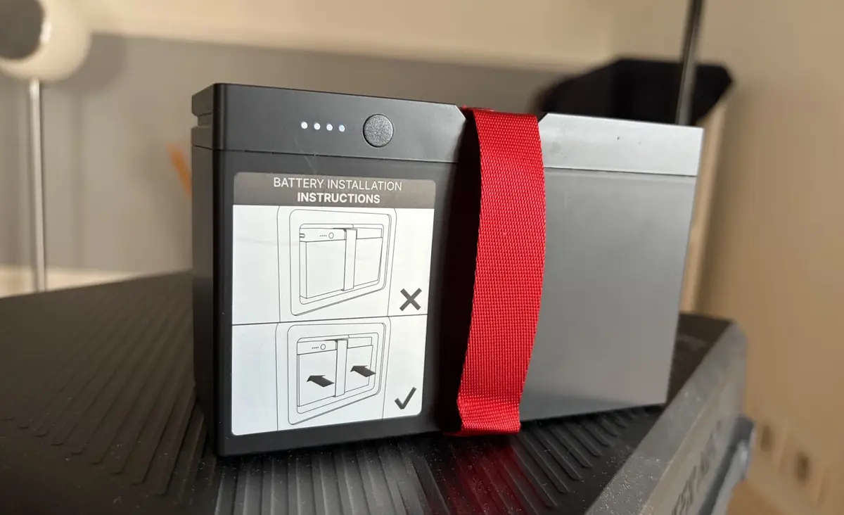 La batterie amovible avec ses t&eacute;moins de charge et une sangle