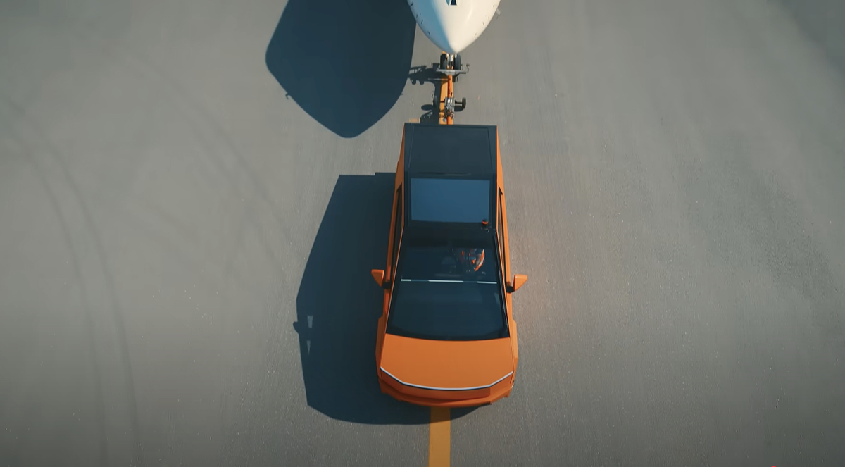 En toute tranquillité, ce Cybertruck (orange) tracte un jet privé